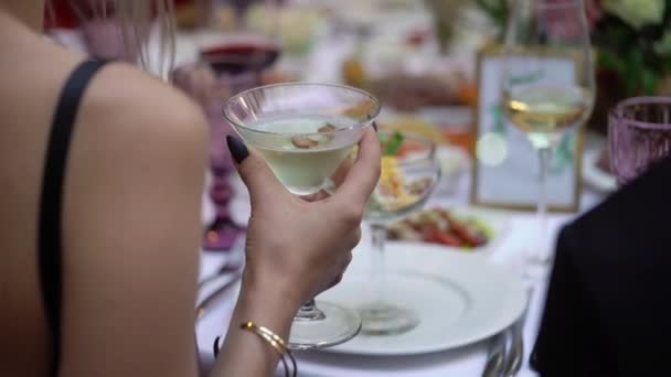 Persona que sostiene una copa de vino o champán u otra bebida alcohólica en la mano en la fiesta . — Vídeos de Stock