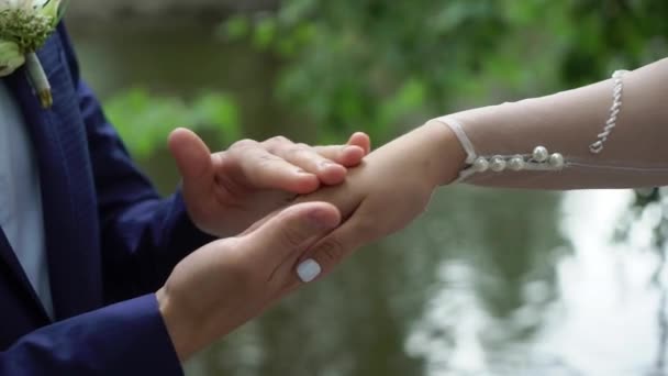 Esküvői pár egy parkban. Menyasszony és vőlegény kéz a kézben — Stock videók