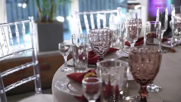 Vasos, platos, cubiertos y servilletas. Mesas decoradas con flores para la fiesta. Recepción de la boda, cumpleaños, aniversario. — Vídeo de stock