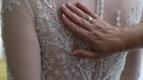 Η παράνυμφος βοηθάει τη νύφη να φορέσει το νυφικό της. Πολυτελές νυφικό φόρεμα — Αρχείο Βίντεο