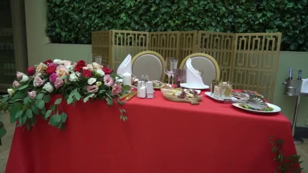 Szemüveg, tányér, evőeszközök és szalvéták. Díszített asztalok virágokkal a partira. Esküvői fogadás, születésnap, évforduló. — Stock videók