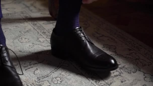 A fiatalember felvette a cipőjét. Öltözködés ünnepi eseményre, üzleti találkozóra vagy esküvőre — Stock videók