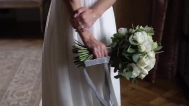 Gelinlik içinde çiçek tutan genç gelin. Beyaz lüks elbise modası