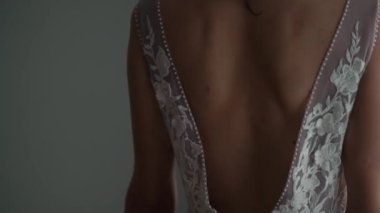 Nedime, genç gelinin gelinliğini giymesine yardım ediyor. Lüks gelinlik.