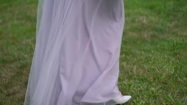 Young bride in wedding dress walking in a park. White luxury gown fashion — Stock Video