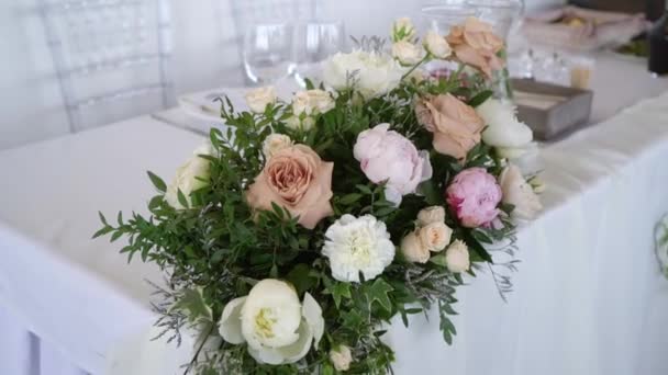 Glasögon, tallrikar, Bestick och servetter. Dekorerade bord med blommor för festen. Bröllopsmottagning, födelsedag, årsdag. — Stockvideo