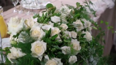 Bardaklar, tabaklar, çatal bıçak ve peçeteler. Parti için çiçeklerle süslenmiş masalar. Düğün resepsiyonu, doğum günü, yıldönümü.