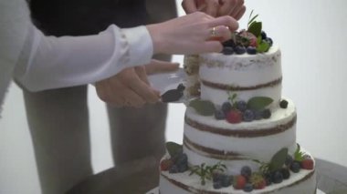 Düğün pastası. Partide geleneksel kutlama tatlısı. Gelin ve damat bir parça kesti.
