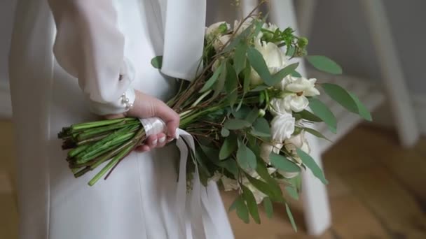 Giovane sposa in abito da sposa in possesso di fiori bouquet all'interno. Bianco moda abito di lusso — Video Stock