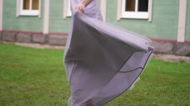 Jonge bruid in trouwjurk cirkelend in een park. Witte luxe jurk mode — Stockvideo