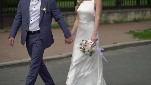 Hochzeitspaar in einer Stadt. Braut und Bräutigam zu Fuß — Stockvideo