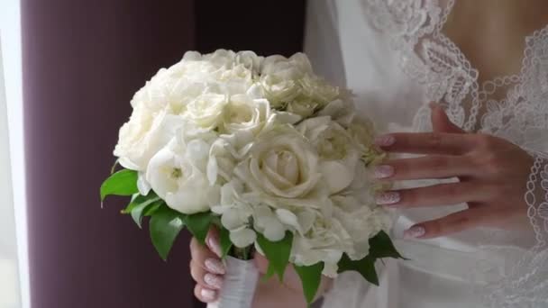 Joven hermosa chica en lencería o albornoz con flores. Ramo de novia, mañana de bodas. Mujer posando — Vídeo de stock