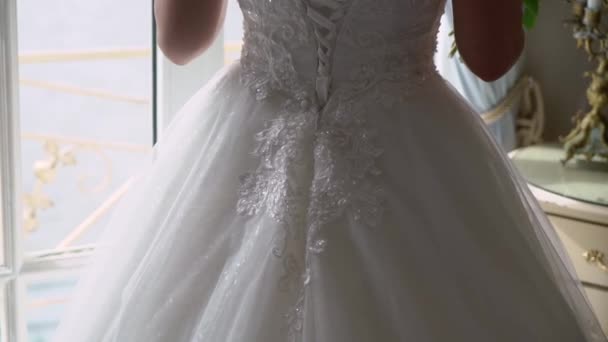 Jeune mariée en robe de mariée tenant bouquet fleurs à l'intérieur. Mode robe de luxe blanche 