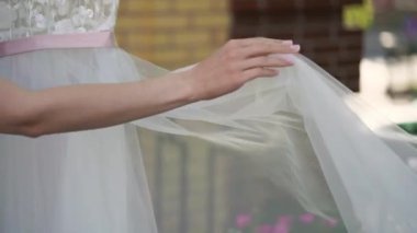 Nedime, genç gelinin gelinliğini giymesine yardım ediyor. Lüks gelinlik.