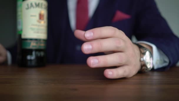 SAINT-PETERSBURG, RUSIA - 19 de agosto de 2019: Hombre con botella de whisky Jameson. Beber alcohol bourbon o coñac masculino . — Vídeos de Stock
