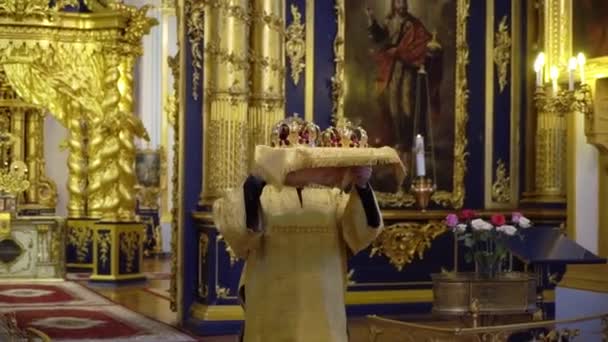 Sankt Petersburg, Ryssland - 4 augusti 2019: Bröllopskronor. Bröllopet i kyrkan. Giftermål i en kristen kyrka. Prästen, bruden och brudgummen där inne. — Stockvideo