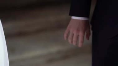 Şehirde bir düğün çifti. Gelin ve damat el ele tutuşuyorlar.