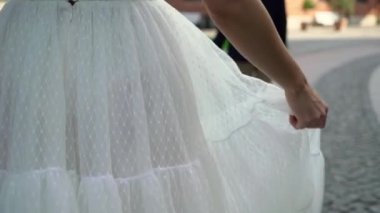 Gelin ve damat şehirde yürüyor. Genç ve güzel bir çift. Gelin çiçekleri buketi