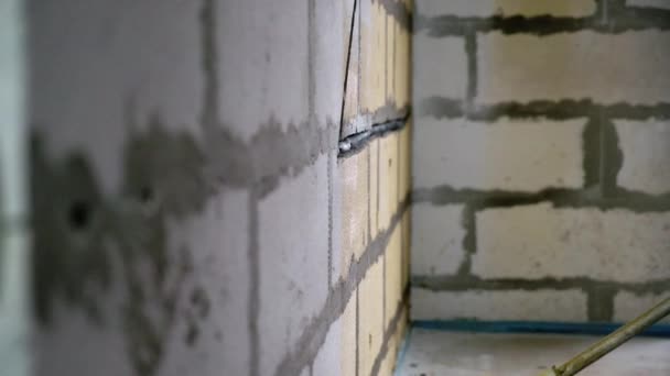 Arbejder på byggepladsen blande gul primer til børste vægge. Renovering og reparation på lejlighed eller hus – Stock-video