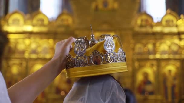 Sankt-Petersburg, Rosja - 4 sierpnia 2019: Korony ślubne. Ślub w Kościele. Ceremonia ślubu w kościele chrześcijańskim. Ksiądz, panna młoda i pan młody w środku. — Wideo stockowe