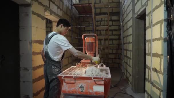 Pleistermortel machine. Automatische pleister. Reparatie of renovatie van huis of appartement. Bouwer in de bouw — Stockvideo