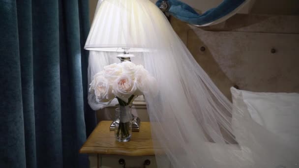 Μπουκέτο γάμου με λευκά τριαντάφυλλα και νυφικό πέπλο στην κρεβατοκάμαρα — Αρχείο Βίντεο