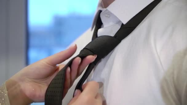 Vrouw fixeren of zetten op zwart stropdas naar haar man — Stockvideo