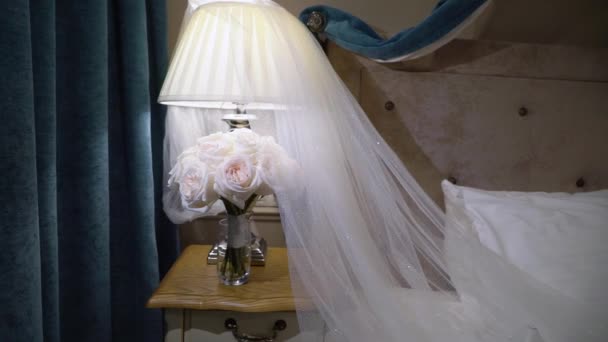 Wedding bouquet with white roses flowers and bridal veil in bedroom — Stock Video