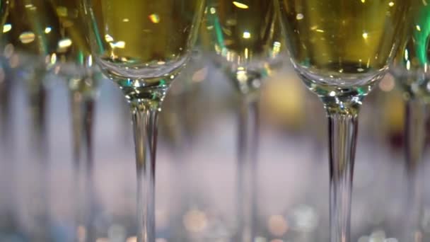 Gelas dengan sampanye atau anggur putih berkilau di pesta — Stok Video