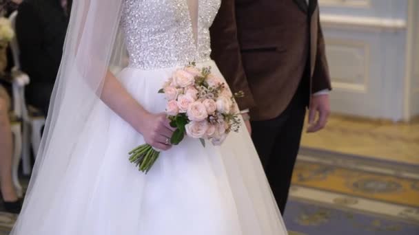 Bride and groom staying at wedding ceremony. Girl holding bouquet of flowers — Stock Video