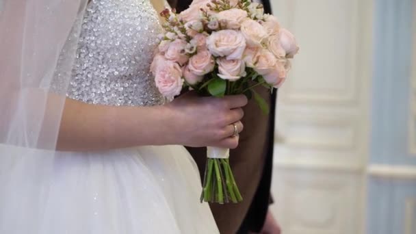 Жених и невеста остаются на свадебной церемонии. Девушка с букетом цветов — стоковое видео