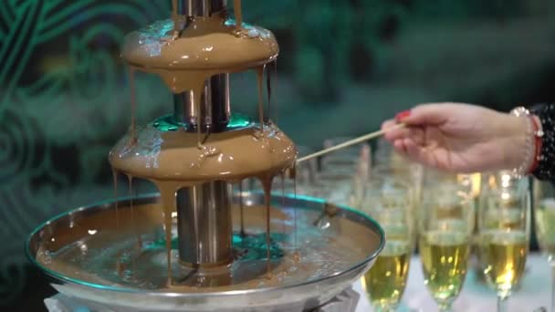 Dompelen van fruit aan vloeibare chocolade fondue fontein — Stockvideo