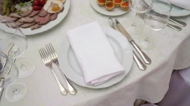 Bardaklar, tabaklar ve peçeteler restoranda. Parti için örtülü bir masa.