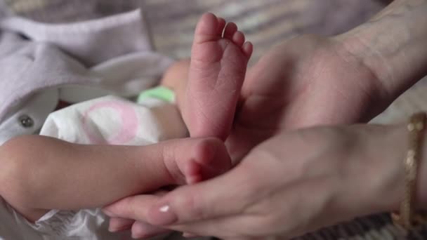 Mom holding her newborn baby legs — Stockvideo