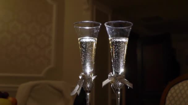 Trouwringen vallen op glas met champagne slowmotion — Stockvideo