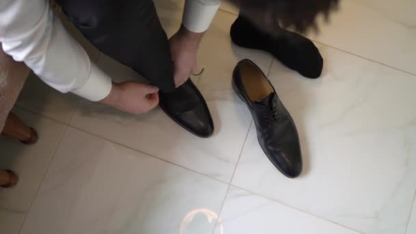 Seorang pria mengenakan sepatu dan mengikat tali sepatu — Stok Video