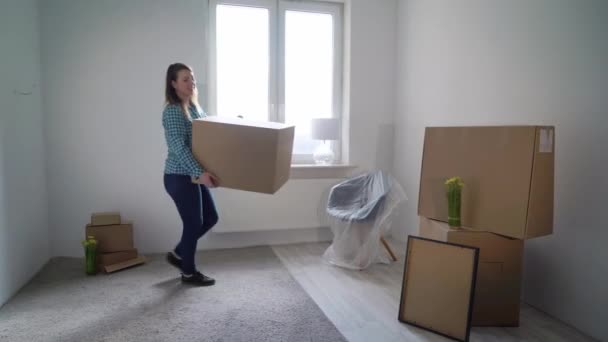 Pindah ke rumah baru. Seorang wanita membawa kartunis kotak, pemilik apartemen — Stok Video