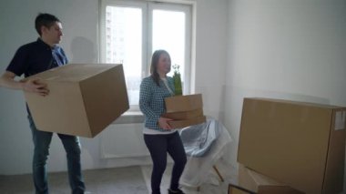 Yeni bir eve taşınıyorum. Aile bir karton kutu taşıyor, apartman sahibi.