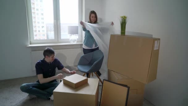 Verhuizen naar een nieuw huis. Familie heeft een doos karton, appartement eigenaar — Stockvideo