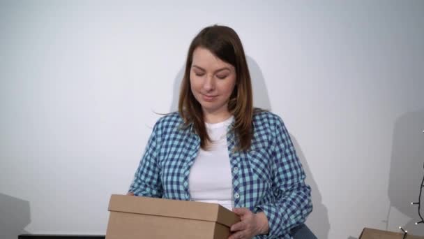Verhuizen naar een nieuw appartement. De eigenaar van het huis opende een kartonnen doos. — Stockvideo