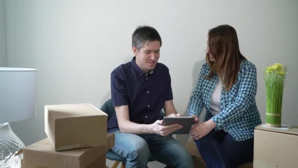 Young couple moving in new home. Sitting on floor and relaxing — Stock Video