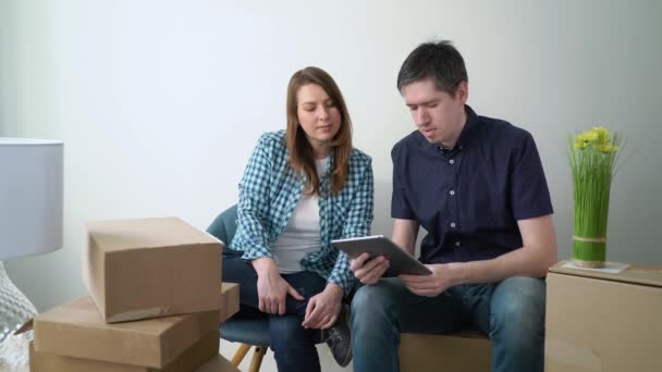 Una pareja joven se muda a un nuevo hogar. Sentado en el suelo y relajante — Vídeo de stock