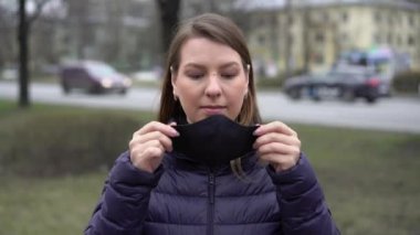 Kadın şehirde yüz koruyucu maske takıyor. Salgın Covid-19 Coronavirüs