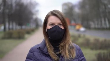 Şehirde koruyucu maskeli bir kadın. Salgın salgın covid-19 coronavirüs