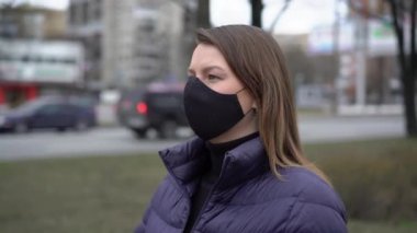 Şehirde koruyucu maskeli bir kadın. Salgın salgın covid-19 coronavirüs