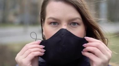 Kadın şehirde yüz koruyucu maske takıyor. Salgın Covid-19 Coronavirüs