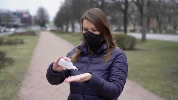 Kentte el dezenfektanı covid-19 koronavirüsü olan koruyucu maskeli bir kadın. — Stok video