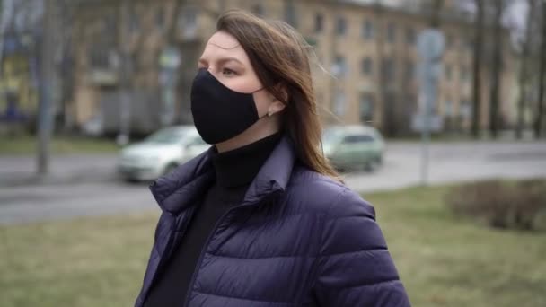 Uma mulher com máscara protectora numa cidade. Epidemia pandémica covid-19 coronavírus — Vídeo de Stock