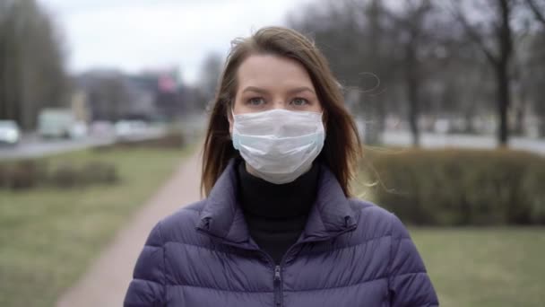 Frau mit Gesichtsschutzmaske in einer Stadt. Epidemische Pandemie Covid-19 Coronavirus — Stockvideo