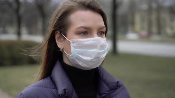 Een vrouw met een gezichtsmasker in een stad. Epidemische pandemische covid-19 coronavirus — Stockvideo